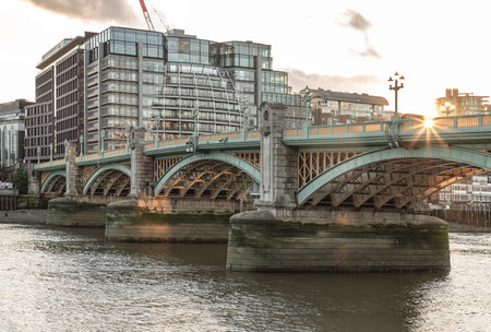 London, UK - Nov 07, 2023 - View of Southwark Bridge (formerly known as Queen Street Bridge) cross The River Thames with Modern buildings in the background at city of london. Turquoise cast iron arches bridge, Selective focus.の写真素材