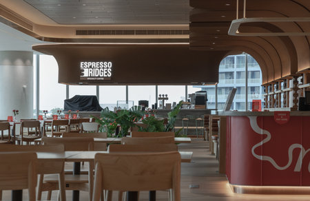 Bangkok,Thailand - 18 Oct, 2025 - Contemporary design meets urban views in this modern cafe, featuring graceful, curved wooden elements and large windows overlooking the city.のeditorial素材