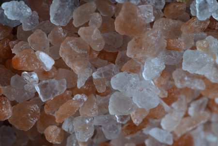 Close-up view of Pink Himalayan Salt on Bright colors textured surface. Crystals and crushed blocks of natural pink salt in the background, Chipped Himalayan salt stone, Selective focus.の写真素材