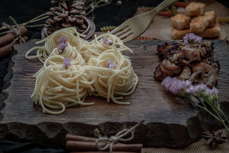 Spaghetti with Roasted Chicken with Black Pepper on a wooden plate Served with Crispy butter toast. Selective Focus.の写真素材