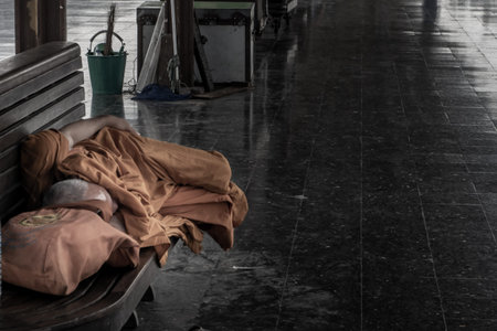Bangkok, thailand - Jul 7, 2019 : A monk is sleep on wooden chairs are waiting for trains in the area provided at Main railway station of Hua Lamphong, Selective focus.の写真素材