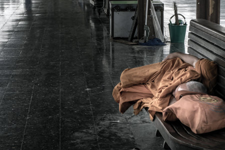 Bangkok, thailand - Jul 7, 2019 : A monk is sleep on wooden chairs are waiting for trains in the area provided at Main railway station of Hua Lamphong, Selective focus.のeditorial素材