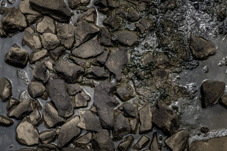 Ballast stone gravel soaked with oil in the railroad tracks, Stone background.