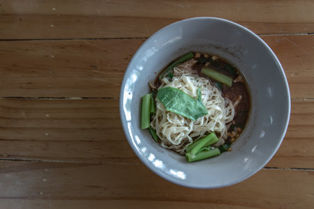 Thai boat noodle soup This delicious Thai noodle soup Local food in Thailand that can be eaten in general is delicious and cheap, Braised pork noodles on the wooden table. Local street food in Thailand, Boat culture noodles style with copy space, Selective focus.の写真素材