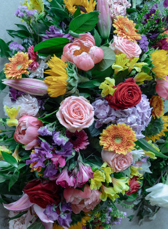 Bursting with color, this exuberant bouquet gathers deep red and soft pink roses alongside a...