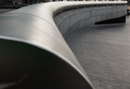 London, UK - Apr 27, 2025 - Guided by a low-angle view, the smooth stainless steel handrail creates...