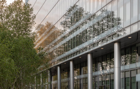 London, UK - Apr 27, 2025 - Rising glass facades dissolve into the canopy, where rigid steel lines...