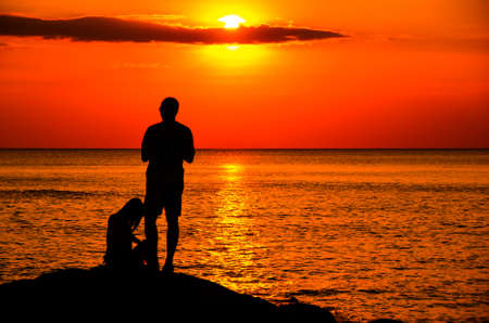 silhoutte couple fishing before sunsetの写真素材