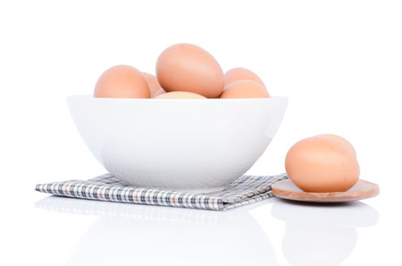 Eggs chicken in a bowl and in a ladly on white background