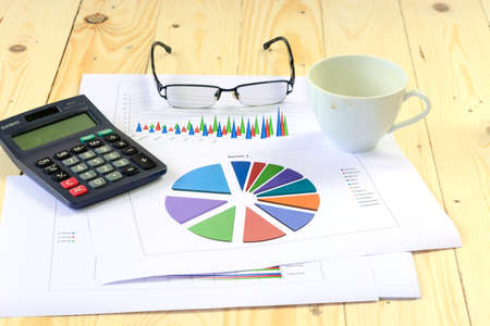 Graph and calculator on a wooden floor in the growth of the businessの写真素材