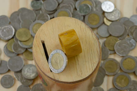Putting coin into piggy bankの写真素材