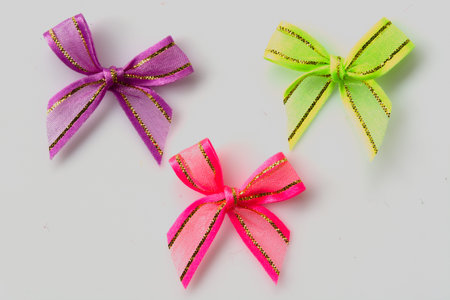 pink, green, purple ribbon bow on white backgroundの写真素材