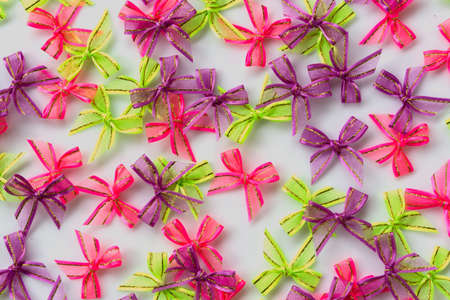 pink, green, purple ribbon bow on white backgroundの写真素材