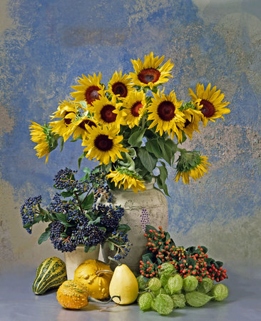 Still life with sunflowers in vase, other flowers and fruitsの写真素材