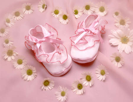 still life with a baby shoes surounded by flowersの写真素材