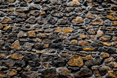 A golden monochromatic stone cladding textured background wallpaper.の写真素材