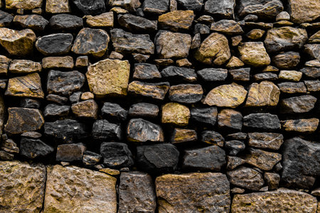 Golden monochromatic Stone-cladded textured wall background.の写真素材