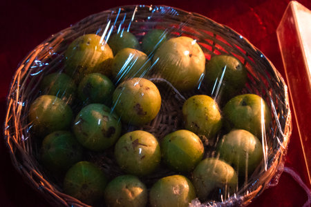 Collection of Indian gooseberries(Amla)on a wicker basket,packed with cling film.の写真素材