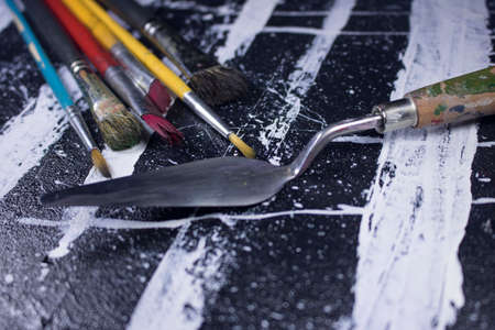 paint brush on grungy black and white acrylic paint canvasの写真素材