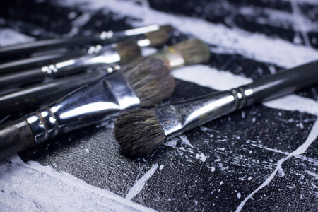 paint brush on grungy black and white acrylic paint canvasの写真素材