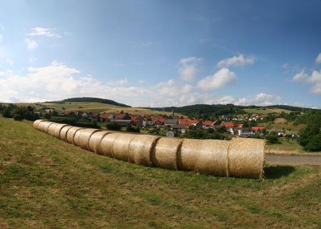Haybales in a german landscape in the north of Hesse. In the background the village of MÃ¼hlbach...