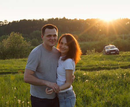 Smiling couple with the car in green fieldの写真素材