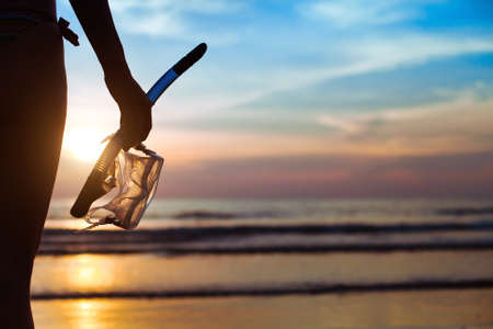 diving, silhouette of hand with equipment for snorkeling, on the beachの写真素材