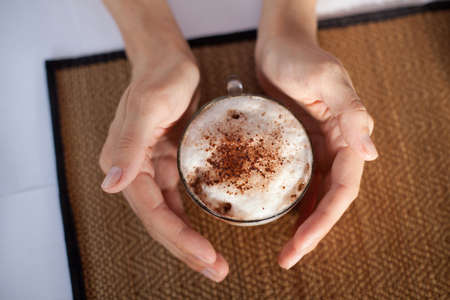 a cup of coffee in handsの写真素材