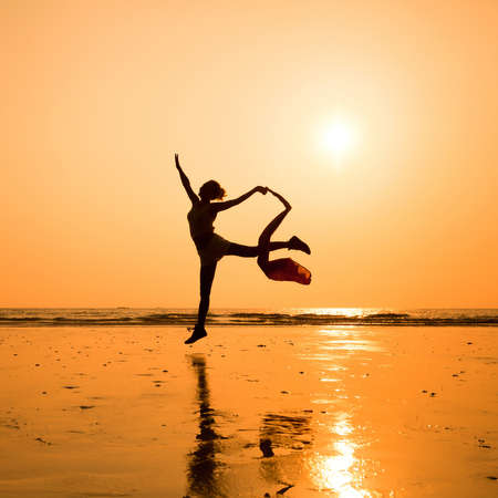 silhouette of dancing woman on the beachの写真素材