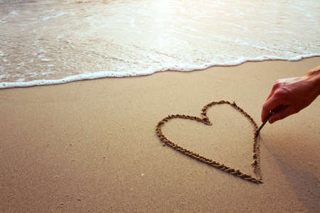 heart on the beach, hand drawing on sandの写真素材