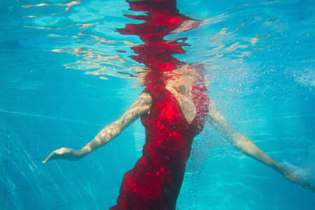 fashion woman in red dress underwaterの写真素材