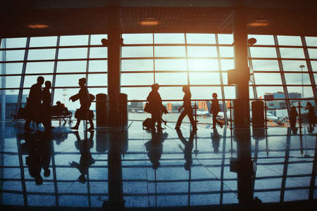 business travel, silhouettes of walking people in the airportの写真素材