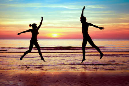 happy couple jumping on the beach, summer vacationsの写真素材