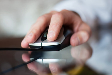 close up of hand with computer mouse on blurred background