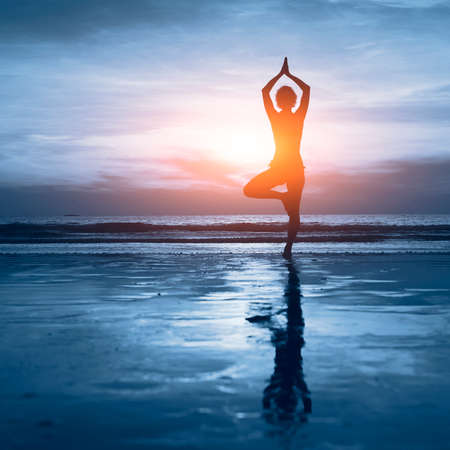 wellness concept, beautiful silhouette of woman practicing yogaの写真素材
