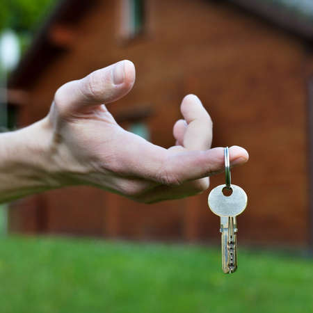 buy cottage, real estate concept, keys in the handの写真素材