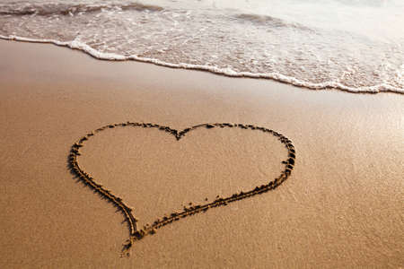 Heart drawn on the sandy beach, valentines day backgroundの写真素材