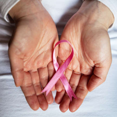 cancer concept, pink ribbon in the handsの写真素材