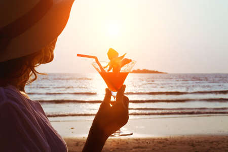 woman with cocktail on the beachの写真素材