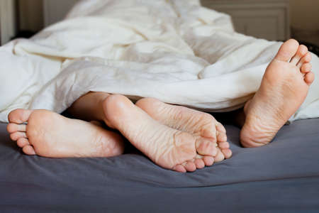 Lover's feet in the bedの写真素材