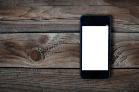 black smart phone with isolated screen on old wooden deskの写真素材