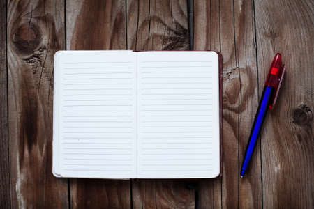 Blank notepad on old wooden table with  penの写真素材