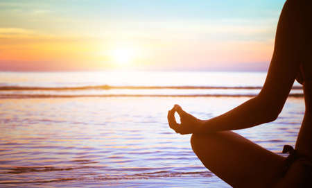 meditation concept, yoga practice on the beach at sunsetの写真素材