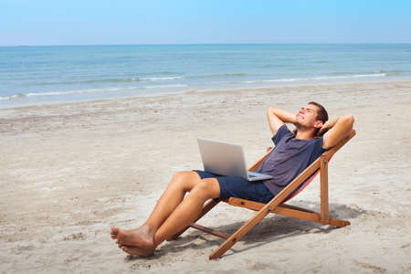 freelancer with laptop on the beach, successful happy business man relaxing, freelance workの写真素材