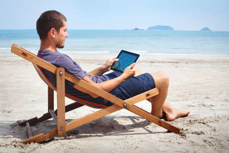 business man working with tablet on the beachの写真素材