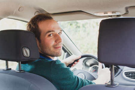 portrait of driver in the car or taxi, young caucasian manの写真素材