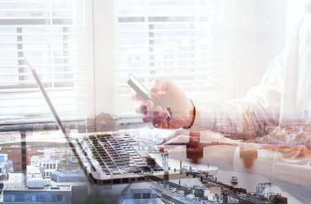 double exposure of hands of business man using smartphone in the office, London cityscapeの写真素材