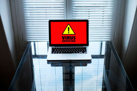 computer virus, alert sign on the screen of laptop in dark roomの写真素材