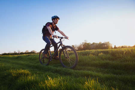 outdoor sport, young man riding bicycle in the natureの写真素材
