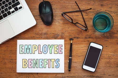 employee benefits concept, note in the notepad on wooden tableの写真素材